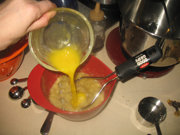 adding egg to banana and oil