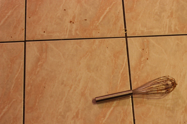 whisk on floor with batter bits