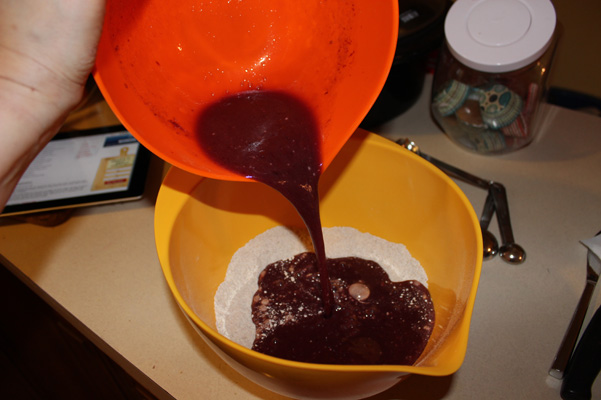 pouring liquid ingredients into flour mixture