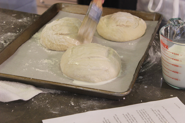 bread dough, getting brushed with milk